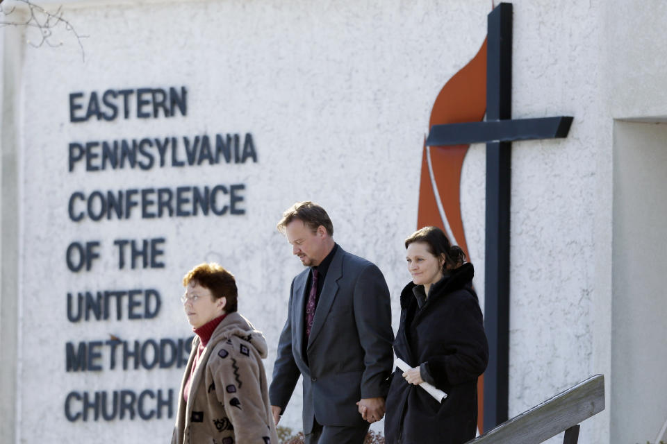 FILE - In this Thursday, Dec. 19, 2013 file photo, accompanied by his wife Brigitte, right, the Rev. Frank Schaefer, of Lebanon, Pa., center, departs after a meeting with officials at the Eastern Pennsylvania Conference of the United Methodist Church in Norristown, Pa. Church officials have defrocked Schaefer, who officiated his son's gay wedding in Massachusetts. (AP Photo/Matt Rourke)