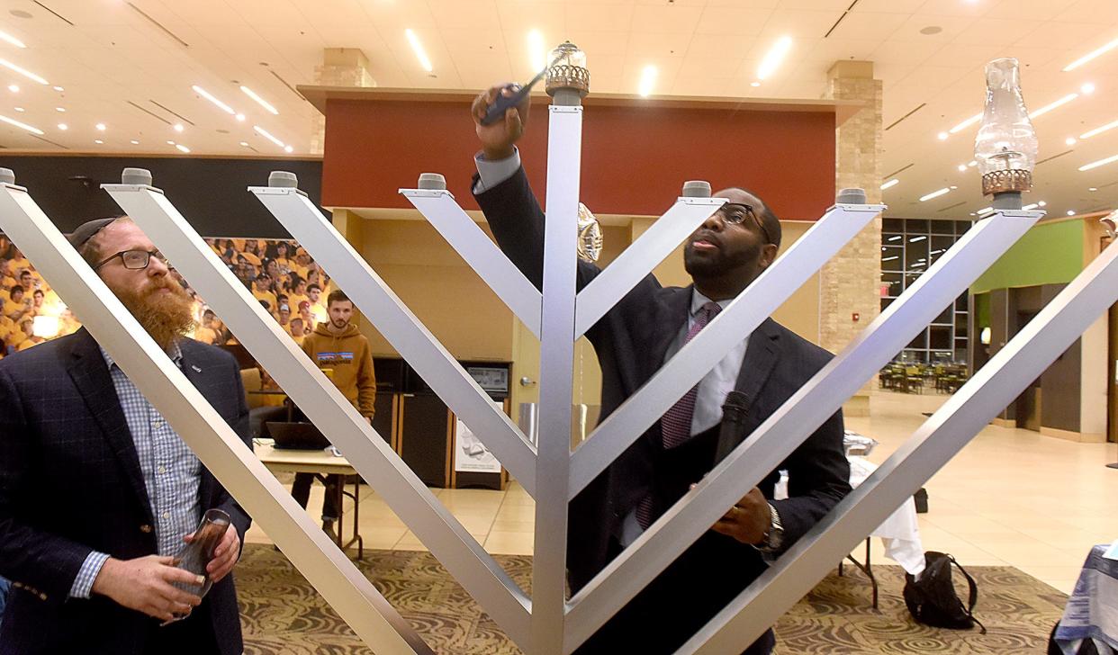 Rabbi Avraham Lapine, left, director of Chabad at Mizzou, watches as Maurice Gipson, vice chancellor of diversity, inclusion and equity at the University of Missouri, lights the shamash candle last year at the MU Student Center.