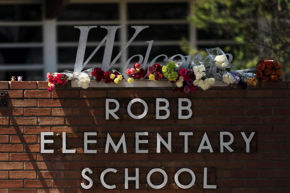 FILE - Flowers are placed around a welcome sign outside Robb Elementary School in Uvalde, Texas, Wednesday, May 25, 2022, to honor the victims killed in a shooting at the school a day earlier. Mass shootings at schools have prompted a growing number of states to encourage the creation of digital maps of facilities to aid emergency responders. An Associated Press analysis found that governors and lawmakers in more than 20 states have enacted or proposed measures setting standards for digital school mapping. (AP Photo/Jae C. Hong, File)