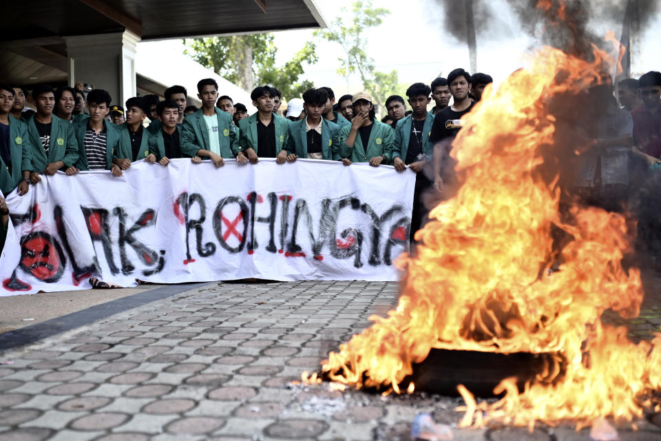 Protesters burn tires during a protest rejecting Rohingya refugees in Banda Aceh, Aceh province, Indonesia, Wednesday, Dec. 27, 2023. Students in Indonesia's Aceh province rallied on Wednesday demanding the government drive away Rohingya refugees arriving by boat in growing numbers as police named more suspects of human trafficking. (AP Photo/Reza Saifullah)