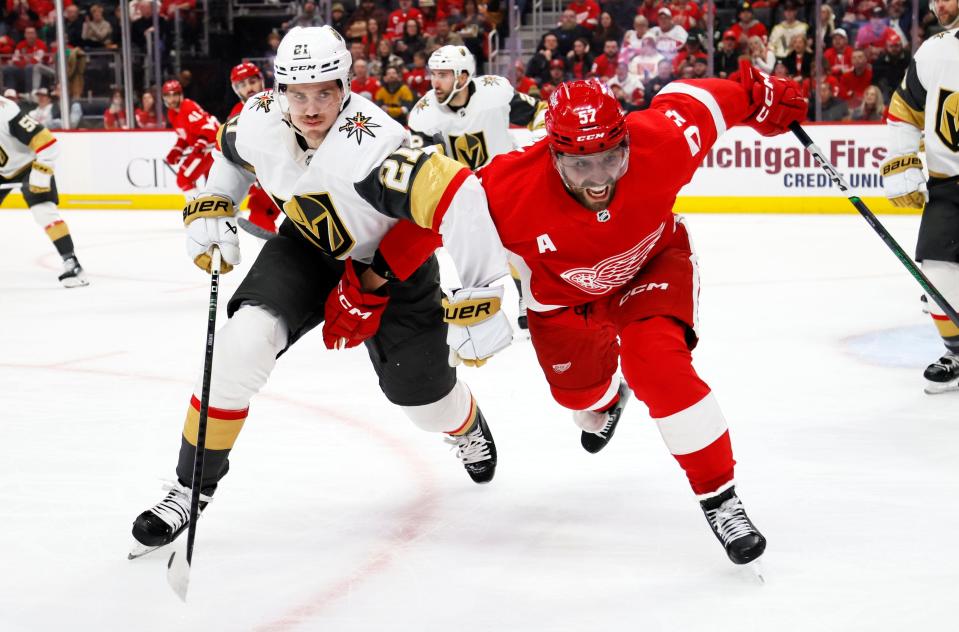 Vegas Golden Knights center Brett Howden (21) and Detroit Red Wings left wing David Perron (57) chase the puck during the first period of an NHL hockey game Saturday, Jan. 27, 2024, in Detroit. (AP Photo/Duane Burleson)