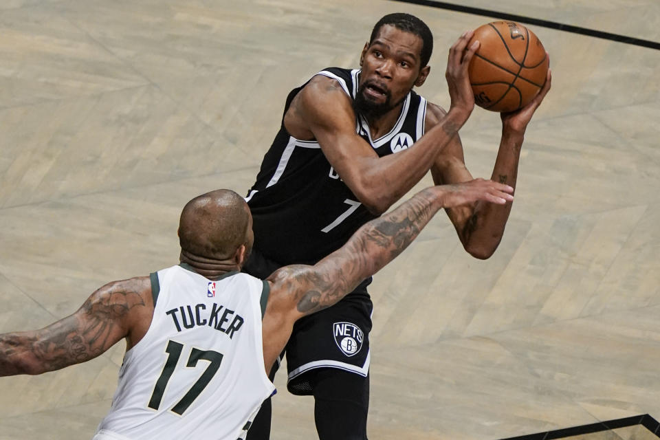 Milwaukee Bucks' P.J. Tucker (17) defends against Brooklyn Nets' Kevin Durant, top, during the first half of Game 7 of a second-round NBA basketball playoff series Saturday, June 19, 2021, in New York. (AP Photo/Frank Franklin II)