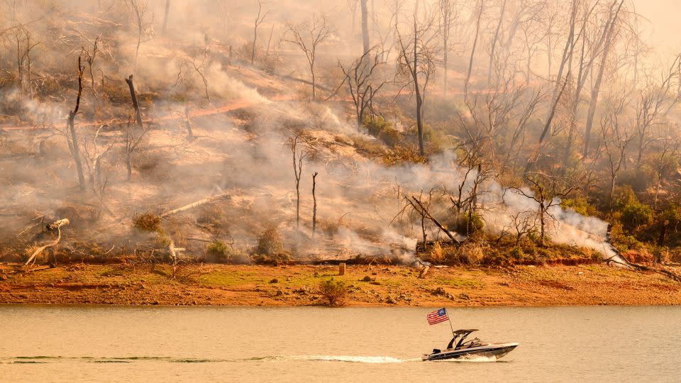 A boat moves along Lake Oroville as the Thompson Fire continues to burn in Oroville, California, on Wednesday. - Josh Edelson/AFP/Getty Images