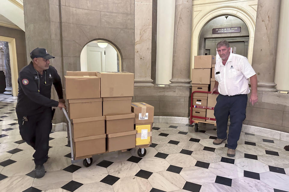 Miembros del personal del Capitolio de Estados Unidos sacan cajas de la oficina del presidente de la Cámara de Representantes, el miércoles 11 de octubre de 2023, en el Capitolio, Washington. (AP Foto/Serkan Gurbuz)