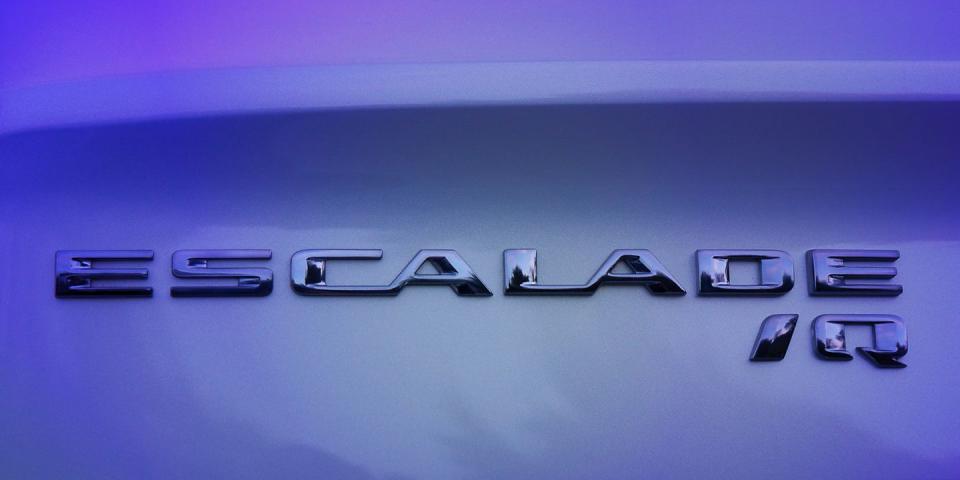 a close up of the cadillac escalade iq name badge seen on the vehicle preproduction model shown actual production model may vary