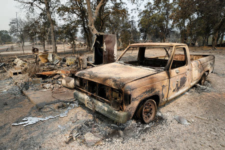 The scorched shell of a truck sits next to a house that burned in the Carr Fire, west of Redding, California, U.S. July 27, 2018. REUTERS/Fred Greaves