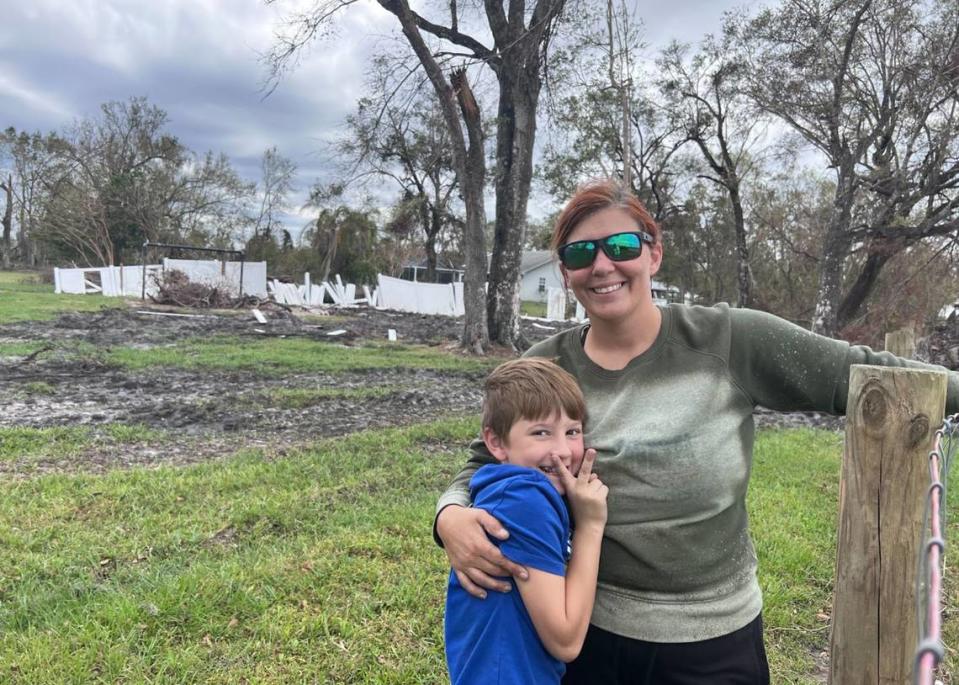 Chelsea Green y su hijo pueden sonreír a pesar de lo que queda atrás, los daños causados por el huracán Ian en su propiedad del Condado Desoto. Clara-Sophia Daly/For the Herald