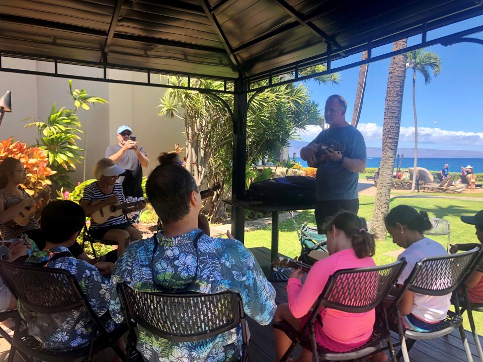 Jason Jerome, owner of Lahaina Music, teaches guests how to play the ukulele at Royal Lahaina Resort on the Hawaiian island of Maui on Monday, July 5. Jerome's business dried up during the pandemic but is starting to come back as tourists return.