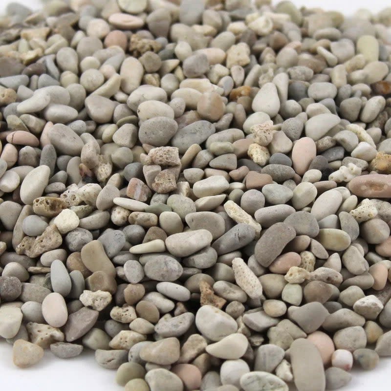 A pile of various small, smooth stones closely packed together