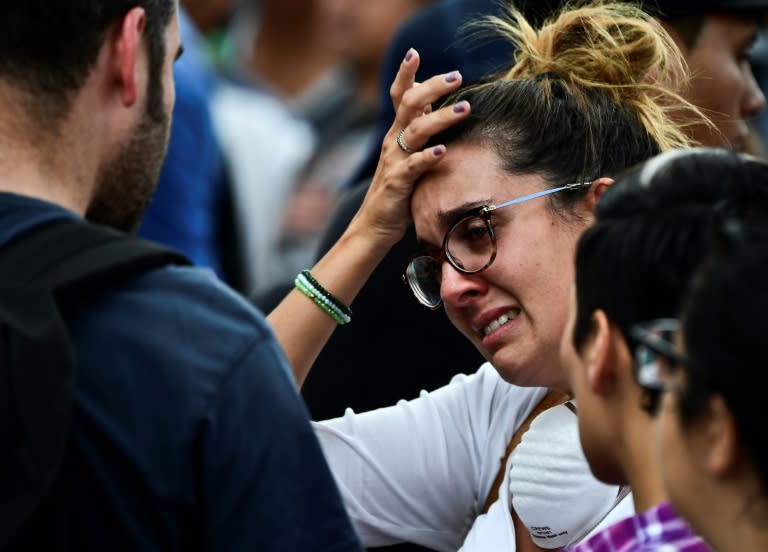 A woman with a relative possibly buried under the rubble of a building waits for news from rescue teams in Mexico City