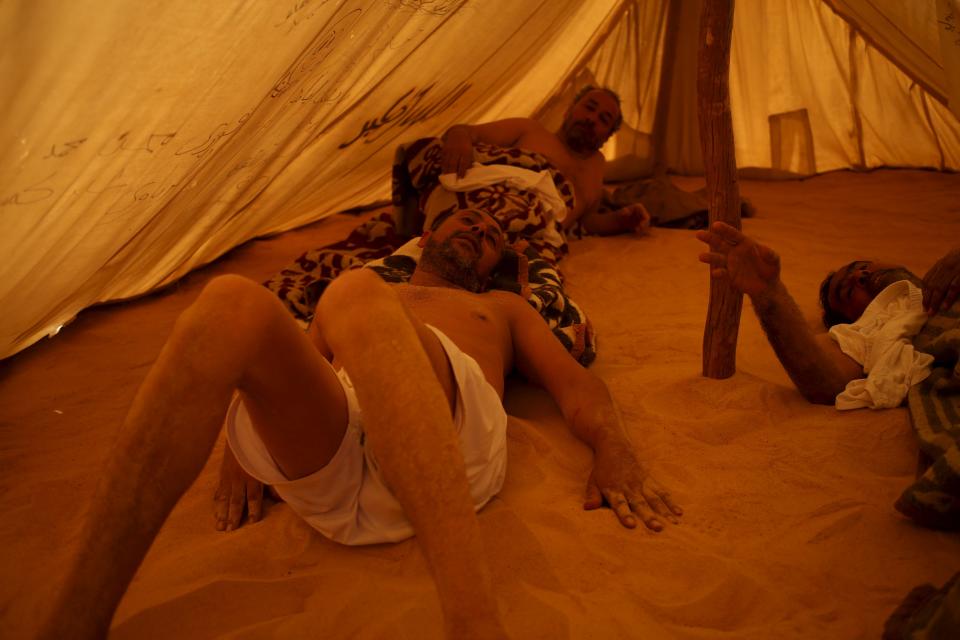 Patients relax in a tent that acts as a sauna after their sand bath in Siwa, Egypt, August 13, 2015. (REUTERS/Asmaa Waguih)