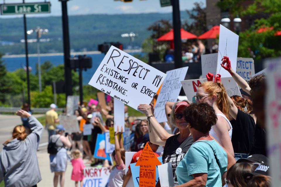 A sign reading "Respect my existence or expect resistance, I'm not ovary-acting" is held during a protest over the overturning of Roe v. Wade by the U.S. Supreme Court along US-31 in front of the hole in downtown Petoskey on Sunday, July 3.