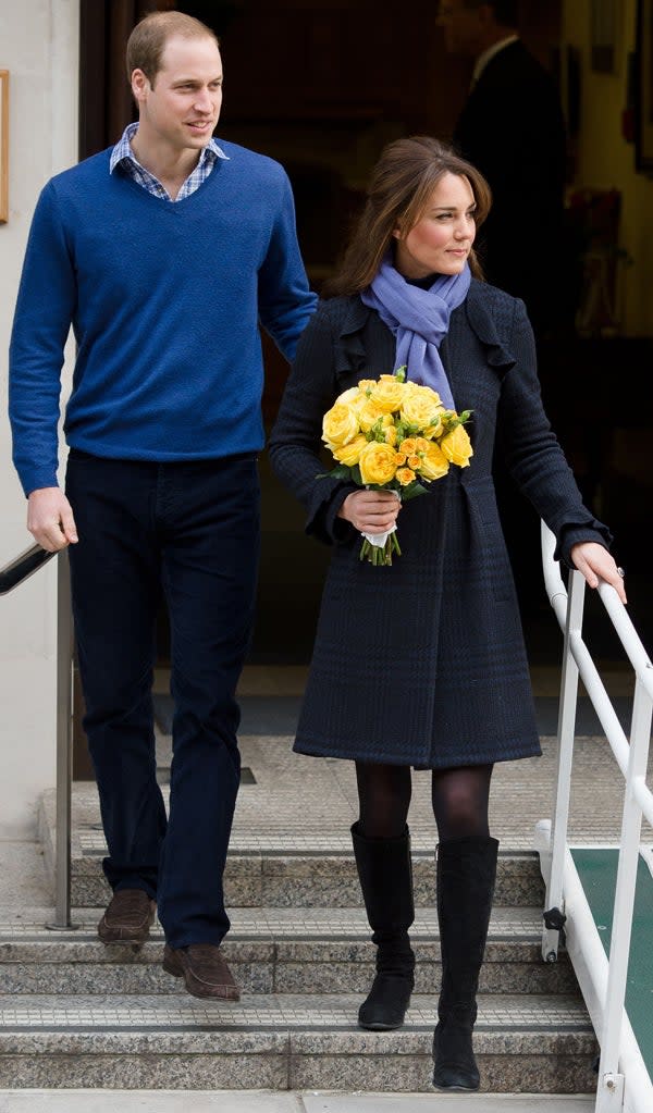 Kate Middleton carrying a bouquet of yellow flowers and looking relaxed, with her husband Prince William at her side.