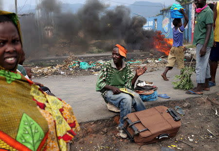 A man works at his street workshop in front of a burning barricade during a protest against President Pierre Nkurunziza's decision to run for a third term in Bujumbura, Burundi, May 27, 2015. REUTERS/Goran Tomasevic