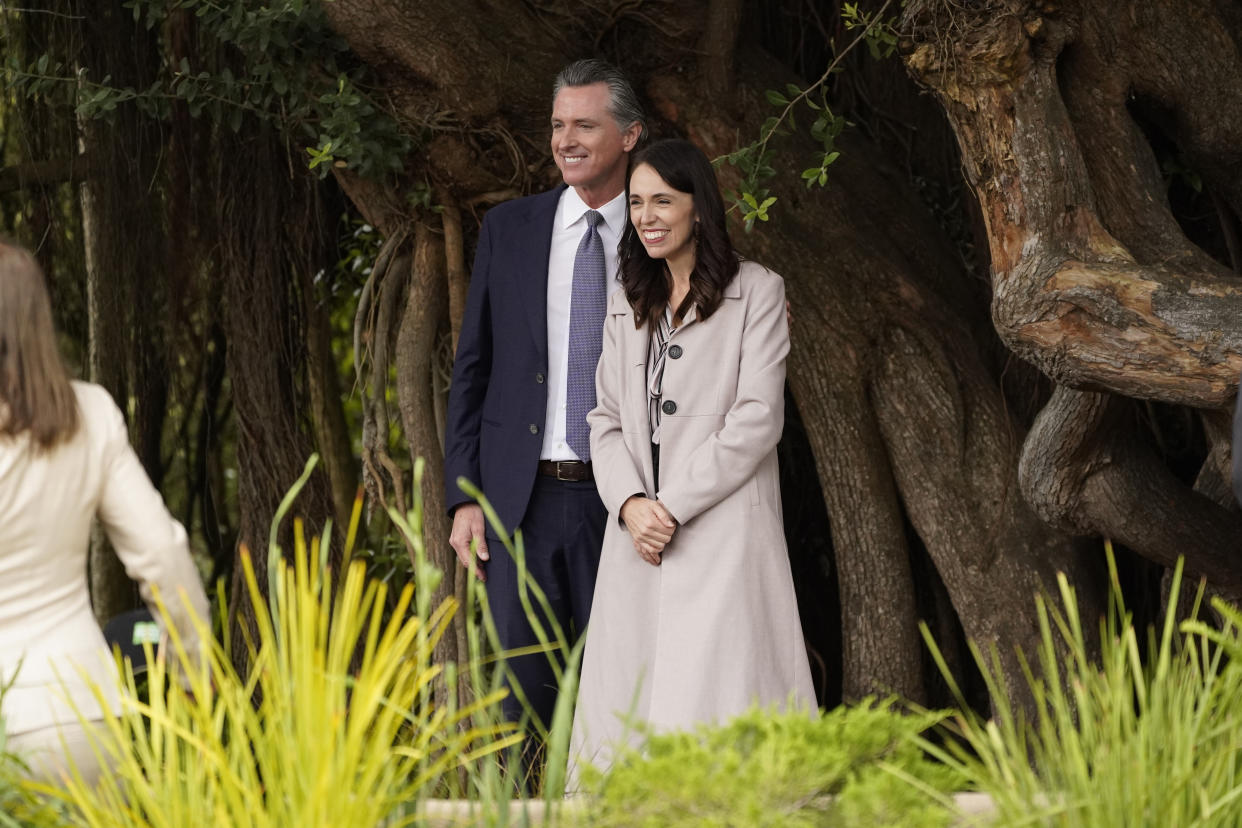 California Gov. Gavin Newsom and New Zealand Prime Minister Jacinda Ardern pose for pictures by a tree after an event at the San Francisco Botanical Garden in San Francisco, Friday, May 27, 2022. Newsom met with Ardern in Golden Gate Park "to establish a new international partnership tackling climate change." (AP Photo/Eric Risberg)