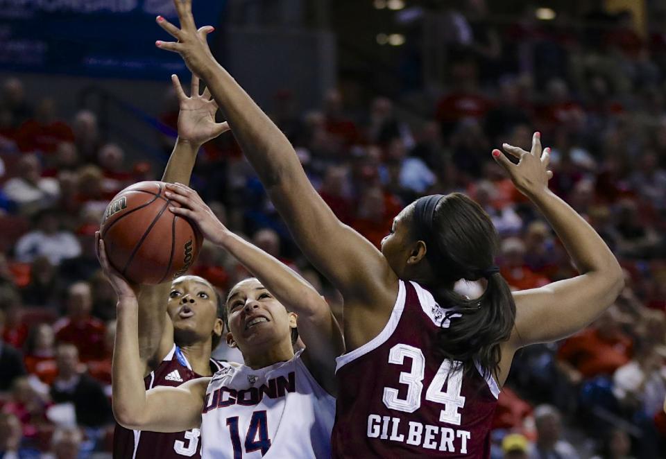 Connecticut's Bria Hartley (14) shoots against the defense of Texas A&M's Courtney Walker, rear, and Texas A&M's Karla Gilbert (34) during the first half of a regional final game in the NCAA college basketball tournament in Lincoln, Neb., Monday, March 31, 2014. (AP Photo/Nati Harnik)