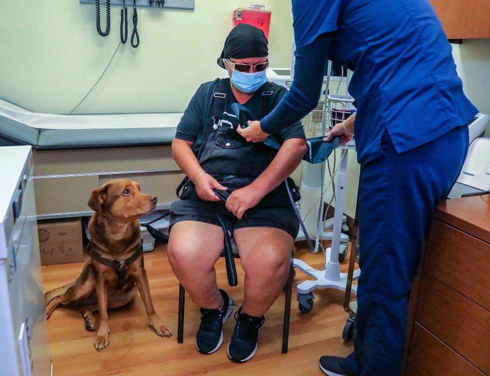 Marie, who is homeless, and lives in her car with her service dog Michelle, prepares to have her blood pressure checked at St. Ann's Place.