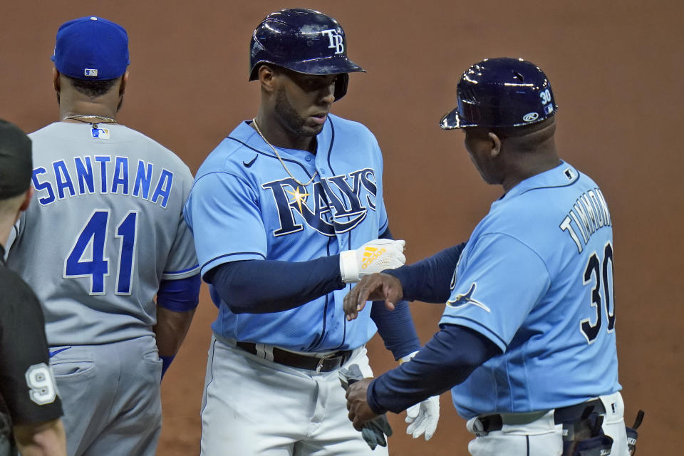 Tampa Bay Rays' Yandy Diaz, center, celebrates his RBI single off Kansas City Royals starting pitcher Brad Keller with first base coach Ozzie Timmons, right, during the third inning of a baseball game Tuesday, May 25, 2021, in St. Petersburg, Fla. (AP Photo/Chris O'Meara)