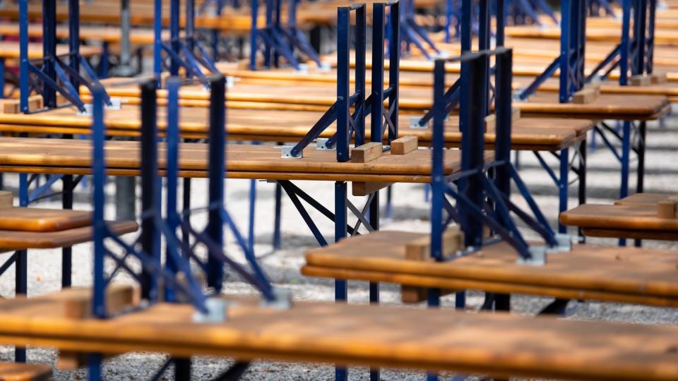 Menschenleer zeigt sich ein Biergarten mit gestapelten Bänken und Tischen im Westpark in München.