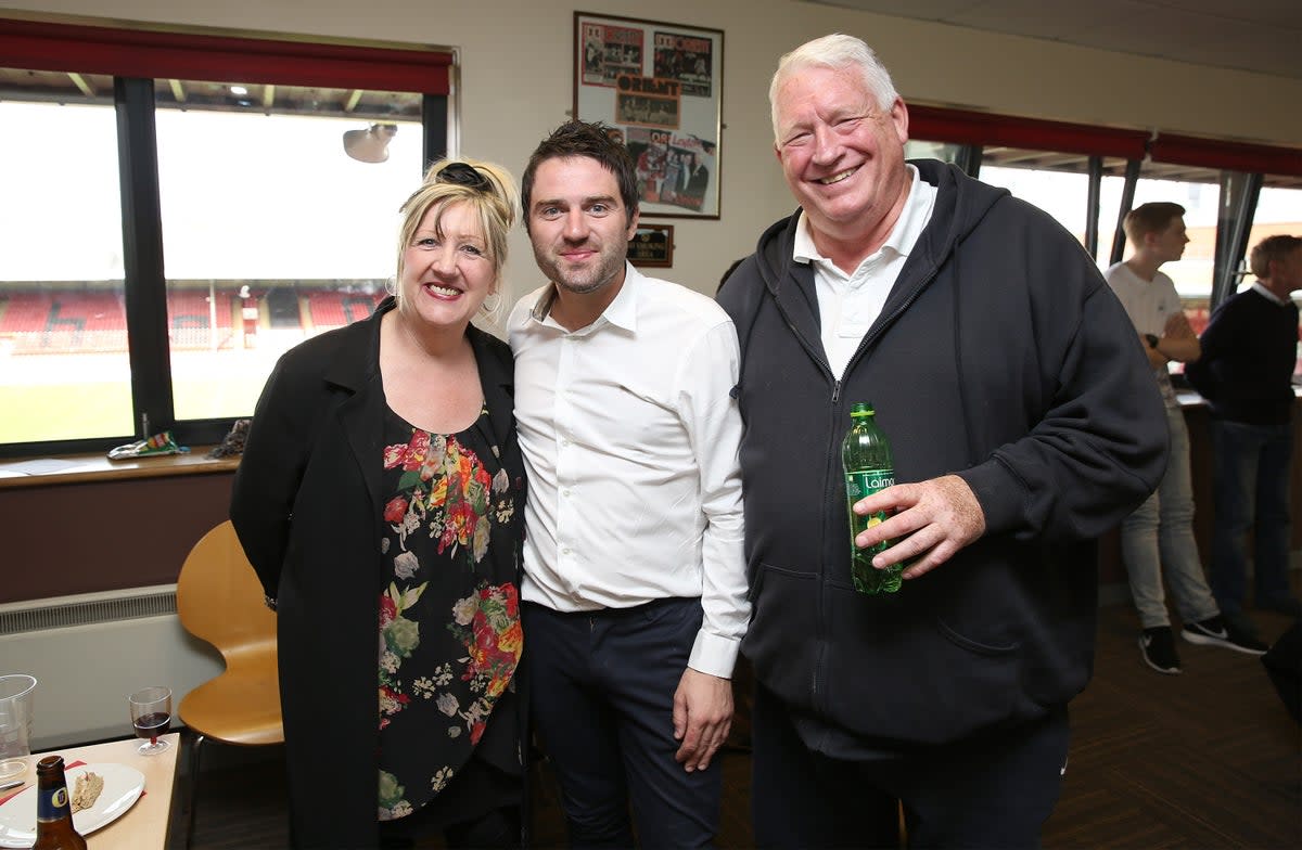 George Gilbey, pictured centre, with his mum Linda and late Stepdad Pete McGarry (Getty)