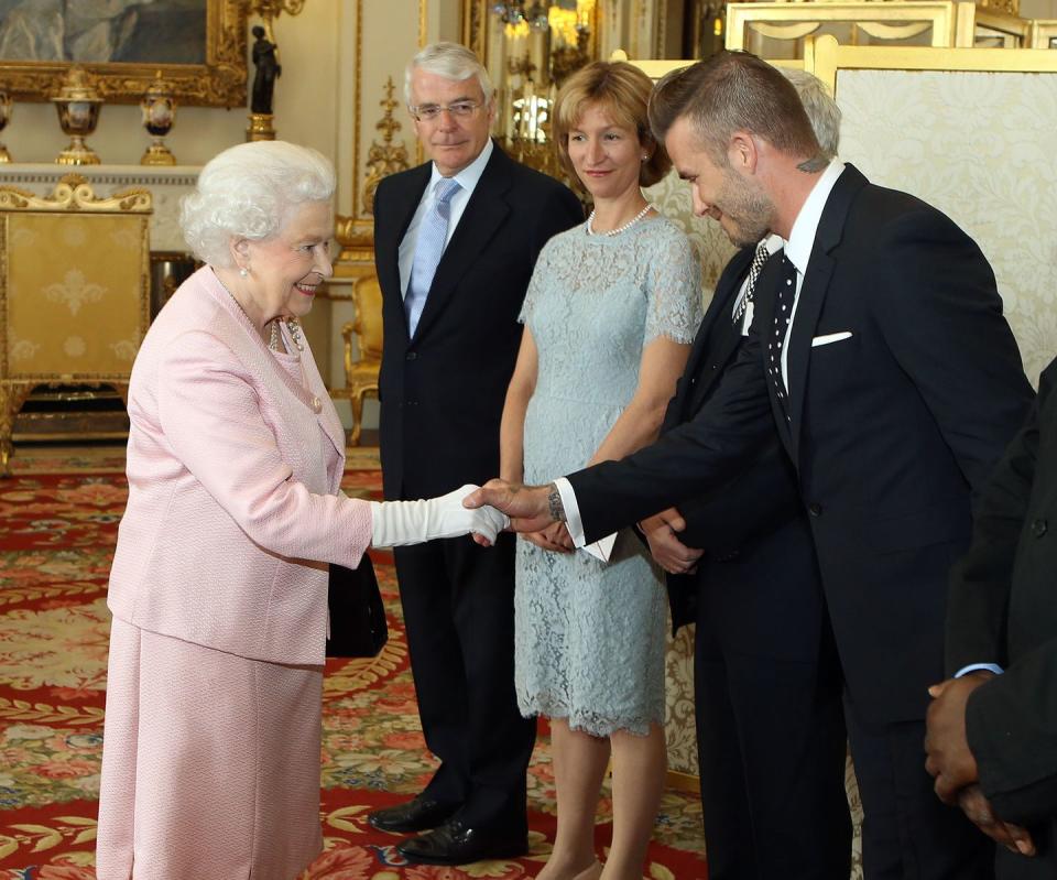 <p>Mr. Beckham first met the Queen in 2003 when he received an OBE. Over a decade later, in 2015, the soccer star opted for a black and white polka dot tie and suit to hang with her Majesty at Buckingham Palace for a reception of the Queen’s Young Leaders program.</p>