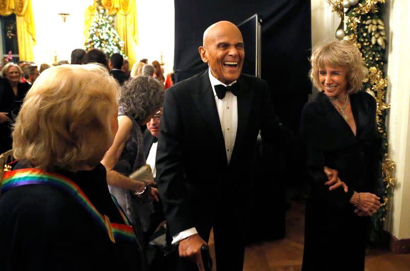 FILE PHOTO: Belafonte laughs with a fellow audience member as they depart after a reception in Washington