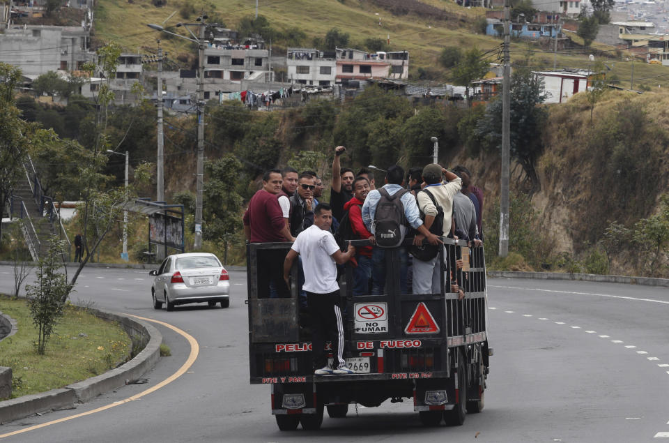 Commuters ride in a trailer during a state of emergency over a transport strike in Quito, Ecuador, Friday, Oct. 4, 2019. Ecuadoran authorities dispatched military vehicles to ferry civilian passengers Friday and arrested several transport union leaders in efforts to halt a strike that shut down taxi, bus and other services in response to a sudden rise in fuel prices. (AP Photo/Dolores Ochoa)