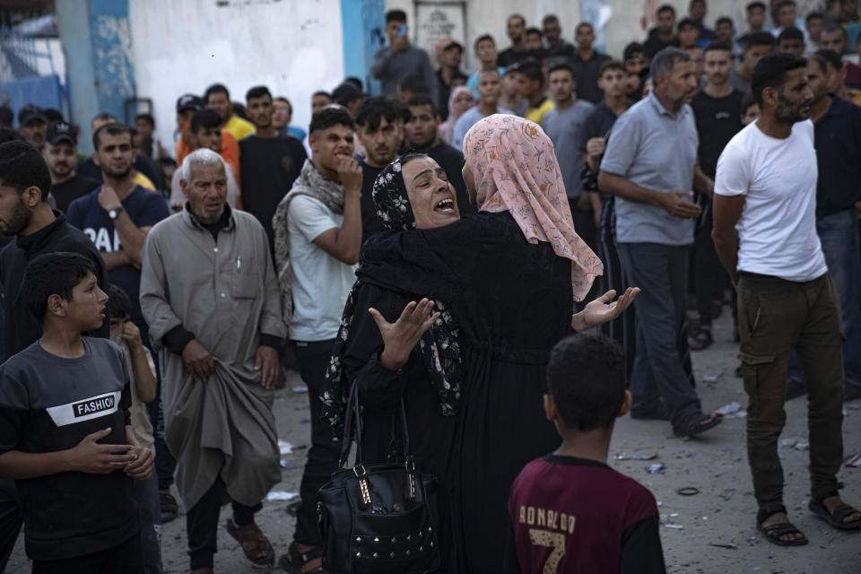 Crying women hug as victims are being pulled from the rubble of a building which collapsed after an airstrike in Khan Younis, Gaza Strip, Saturday, Oct. 21, 2023. (AP Photo/Fatima Shbair)