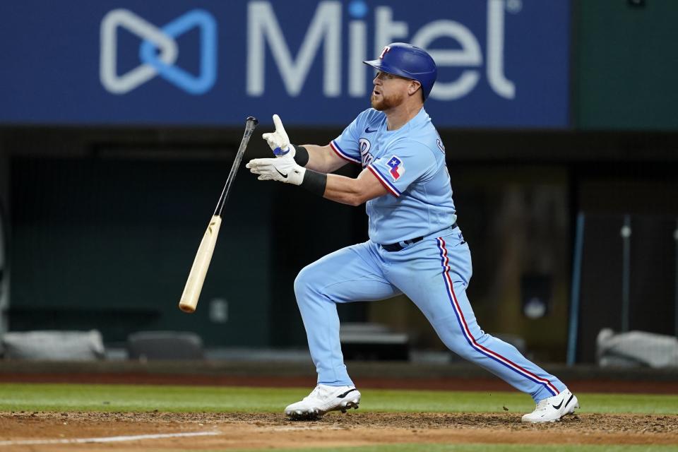 Texas Rangers' Kole Calhoun releases the bat as he watches his two-run home run that also scored Corey Seager in the eighth inning of a baseball game against the Detroit Tigers in Arlington, Texas, Sunday, Aug. 28, 2022. (AP Photo/Tony Gutierrez)