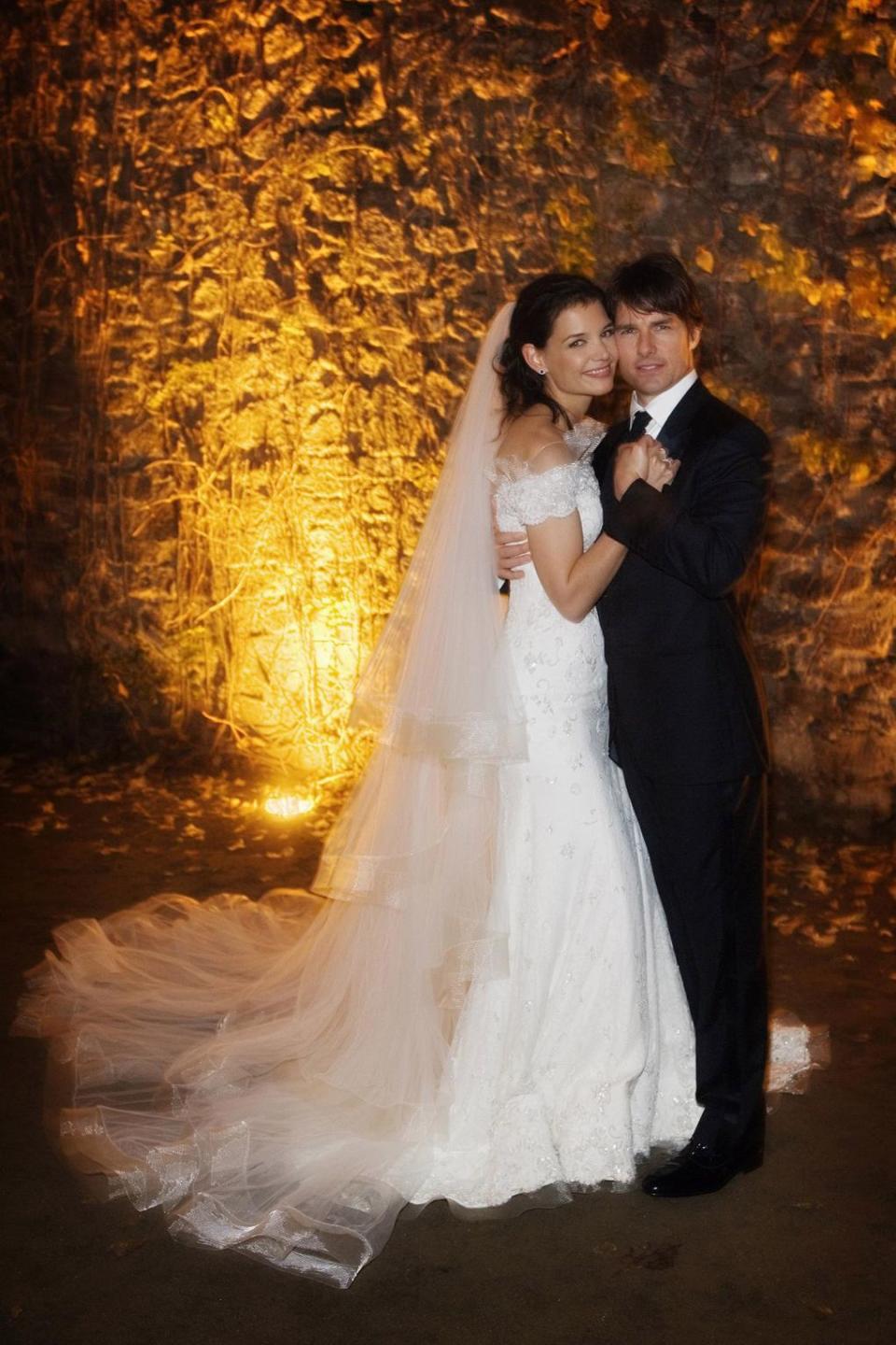<p>Sept mois après la naissance de leur fille, Suri, Katie Holmes et Tom Cruise se dirent “oui” en Italie en Novembre 2006. Elle porta une robe quasi bustier signée Giorgio Armani. Crédit : Getty </p>