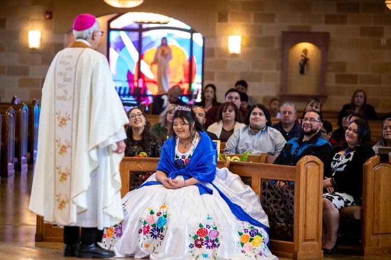 Karina and her family and guests laugh during Bishop Mark Seitz’s homily at her quinceañera Mass at St. Frances Xavier Cabrini Church.