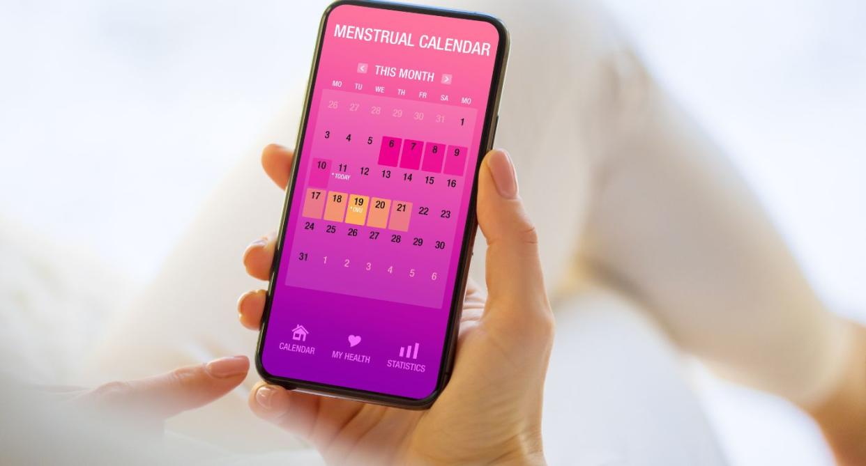 Woman holding app to check period, to help with increasing chances of getting pregnant. (Getty Images)