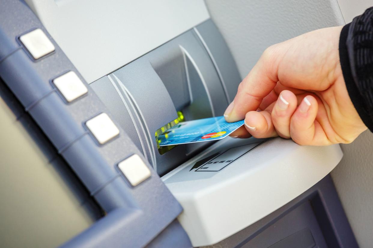 young woman inserting her bank card in an ATM