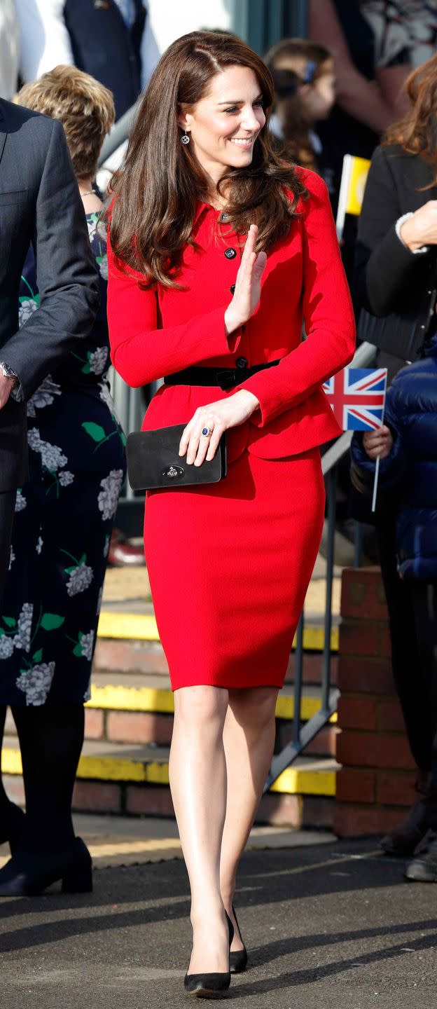 <p>During a Place2Be event, Kate wears a red peplum Luisa Spagnoli suit accented with a black velvet bow and black buttons.</p>