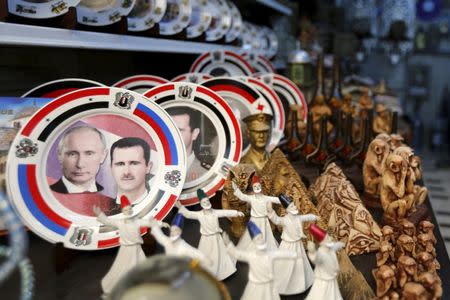 Souvenir plates depicting Syria's President Bashar al-Assad and Russia's President Vladimir Putin are seen among other items for sale in old Damascus, Syria, February 8, 2016. REUTERS/Omar Sanadiki