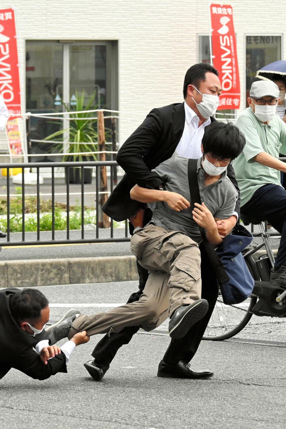 Esta imagen provista por el periódico Asahi Shimbun muestra al sospechoso de asesinar a Shinzo Abe ser derribado por agentes de policía (ASAHI SHIMBUN/AFP via Getty Images)