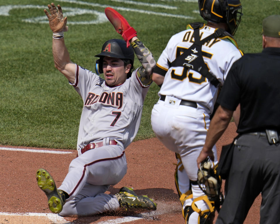 Arizona Diamondbacks' Corbin Carroll (7) scores past Pittsburgh Pirates catcher Jason Delay (55), the second of two runs driven in on a Christian Walker double off Pirates relief pitcher Robert Stephenson during the seventh inning of a baseball game in Pittsburgh, Sunday, May 21, 2023. (AP Photo/Gene J. Puskar)