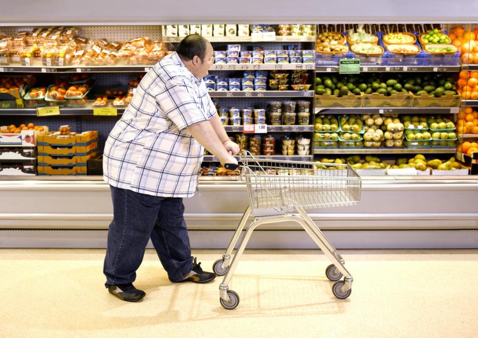 Obesity accounts for nearly half of the cost of chronic disease in the U.S. <a href="https://www.gettyimages.com/detail/photo/overweight-man-passing-by-healthy-food-royalty-free-image/108821354?phrase=overweight+people&adppopup=true" rel="nofollow noopener" target="_blank" data-ylk="slk:Peter Dazeley/The Image Bank via Getty Images;elm:context_link;itc:0;sec:content-canvas" class="link ">Peter Dazeley/The Image Bank via Getty Images</a>