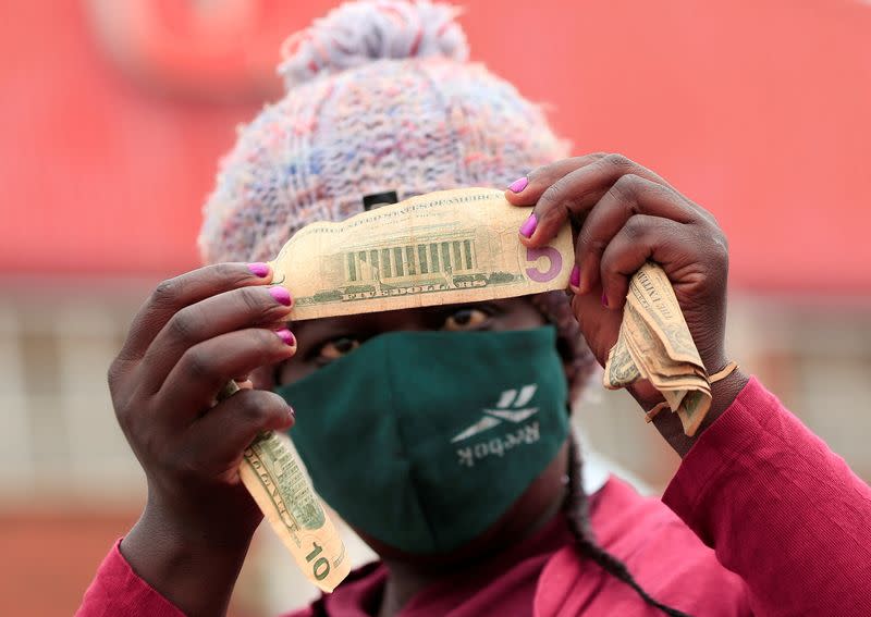 FILE PHOTO: An illegal money changer checks old U.S. dollars at a marketplace in Harare