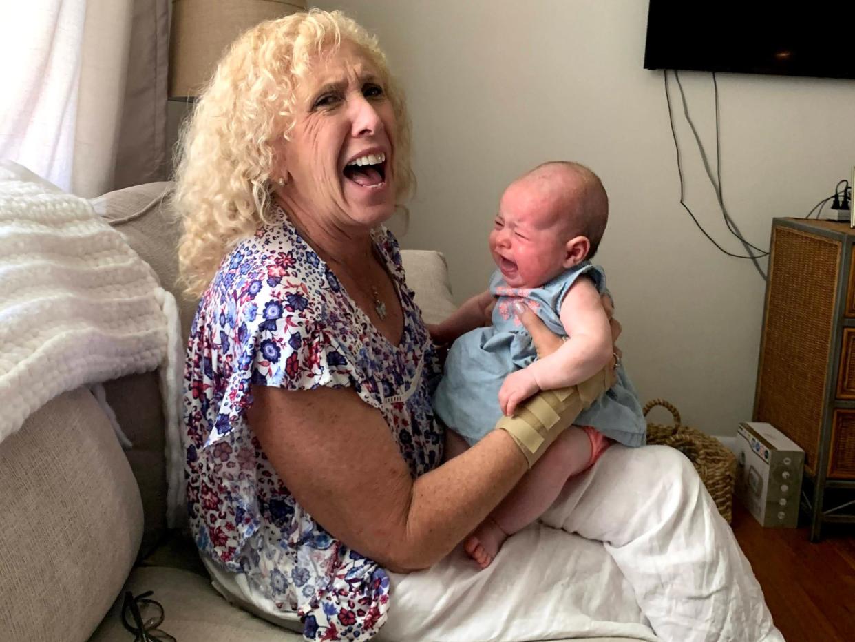 Marjorie Hershberg verzieht scherzhaft das Gesicht, als sie ihre weinende kleine Enkelin Leah im Arm hält. - Copyright: Courtesy of Marjorie Hershberg