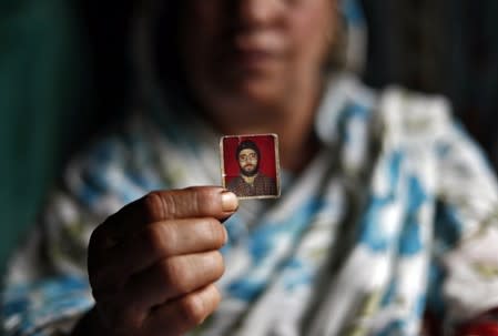 Haseena Malik shows a photograph of her son Uzair Maqbool Malik at her house in south Kashmir's Shopian