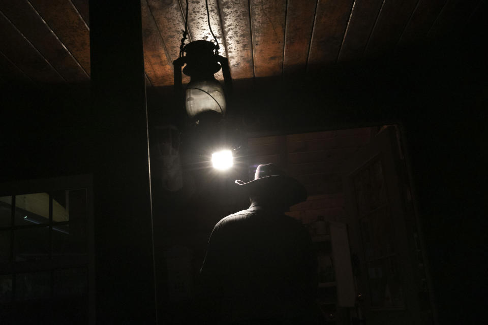 A spotlight illuminates Donald Dutiel's cowboy hat at the entrance to one of his homes at a ranch in New Lexington, Ohio, on Tuesday, July 28, 2020. (AP Photo/Wong Maye-E)