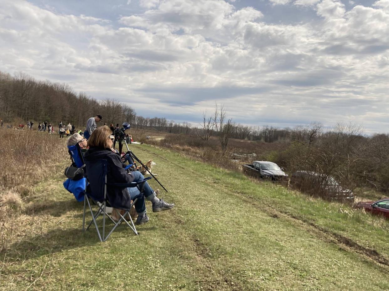 Claudia Babicz and Steve White of Pittsburgh and others from as far away as Florida and Wisconsin watch the April 8, 2024, total solar eclipse at Deer Run Trail in the Sugar Lake Division of the Erie National Wildlife Refuge in Crawford County. "I'll keep smiling all day," said Babicz after the eclipse ended.
