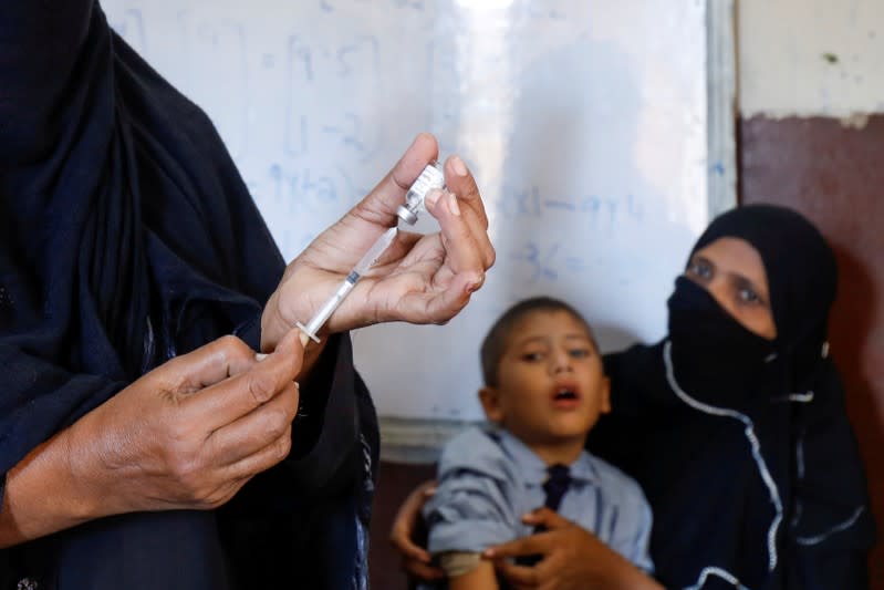 FILE PHOTO: A medical staff member fills a syringe with an anti-typhoid vaccine before administering it to a student during the immunisation campaign at a school in Karachi