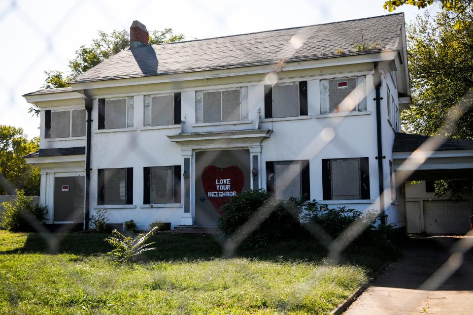 A house at 1755 S. National Ave. has been boarded up and had a chainlink fence placed around it as a group of developers hoping to build a retail development fight with the University Heights Neighborhood Association who is in opposition to the development.