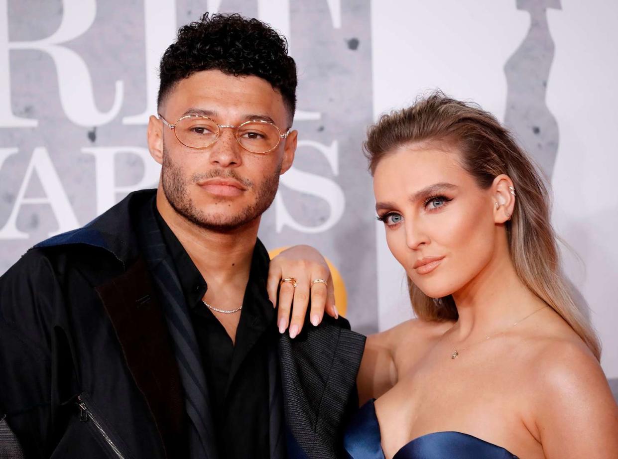 Alex Oxlade-Chamberlain and girlfriend Perrie Edwards (R) pose on the red carpet on arrival for the BRIT Awards 2019 in London on February 20, 2019