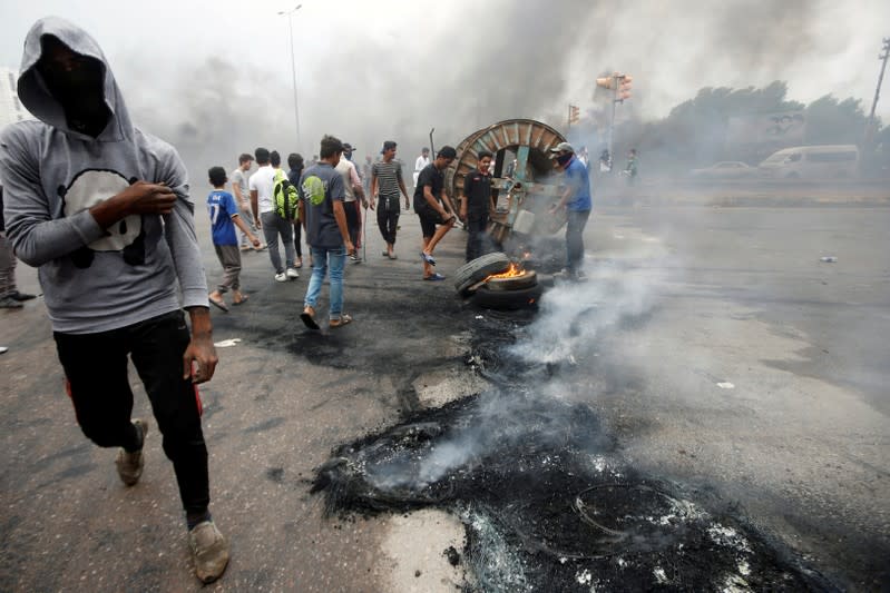 Iraqi protesters burn tires during the ongoing anti-government protests in Basra