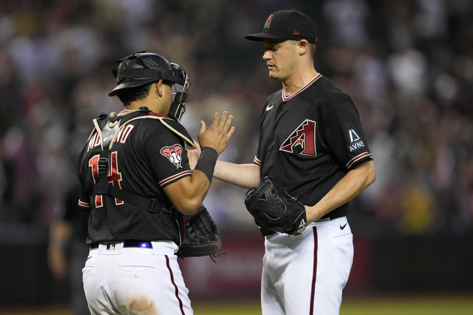 Arizona Diamondbacks relief pitcher Paul Sewald, right, greets catcher Gabriel Moreno after a baseball game against the San Francisco Giants, Tuesday, Sept. 19, 2023, in Phoenix. The Diamondbacks defeated the Giants 8-4. (AP Photo/Matt York)