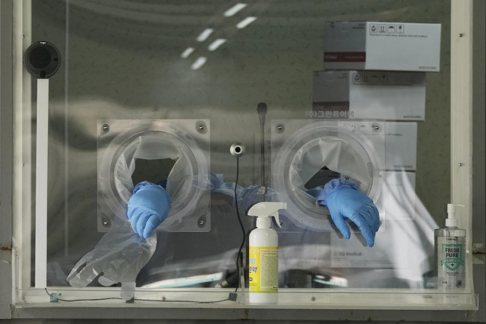 An exhausted worker in a booth rests during COVID-19 testing at a coronavirus testing site in Seoul, South Korea, Tuesday, July 6, 2021. (AP Photo/Ahn Young-joon)