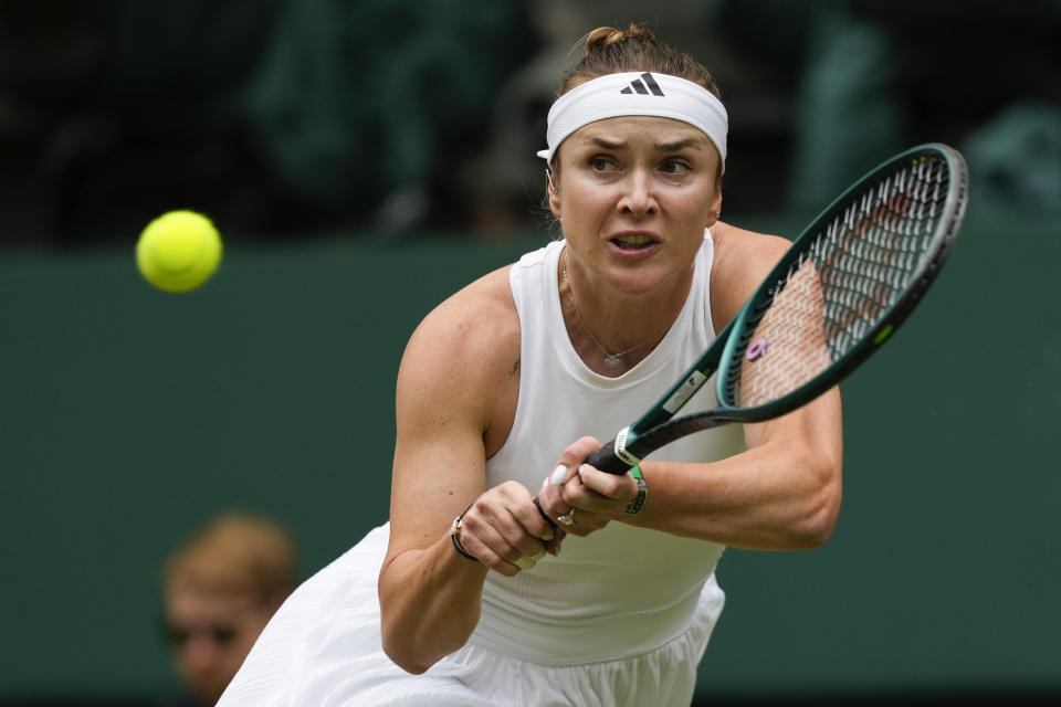 Elina Svitolina of Ukraine plays a backhand return to Elena Rybakina of Kazakhstan during their quarterfinal match at the Wimbledon tennis championships in London, Wednesday, July 10, 2024. (AP Photo/Kirsty Wigglesworth)